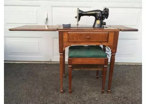 Antique Sewing machine in wood table hutch cabinet with bench seat